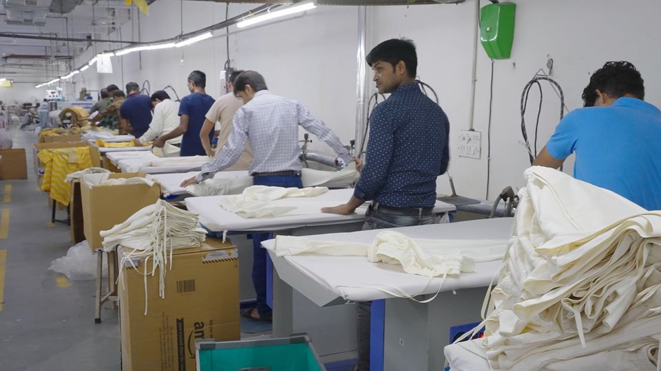 Workers at long tables on a production line.